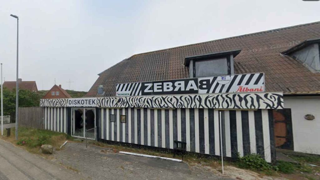 I årevis har ruinen på Nørregade 5 i Hvide Sande, tidligere hjemsted for Diskotek Zebra Bar, været et trist syn og et samtaleemne blandt de lokale. Den faldefærdige bygning, der tidligere har været byens samlingspunkt, som både restauration samt beværtning og natklub, har skabt frustration, men nu kan en løsning være i sigte. foto: GM Hvide Sande Nu